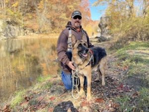 Phillip and dog by a stream.