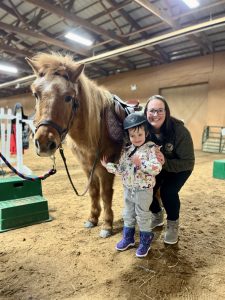 mother and yound child near a pony