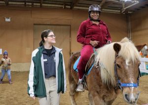 older female veteran rides a horse